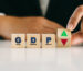 GDP, gross domestic product symbol. Businessman flip cube with up and down arrow. Business financial management concept