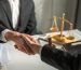 Close up of lawyer male shakehand with female customer in courtroom. Attractive judge attorney sitting on table, working and give advise to consumer in office. Law and Legal business services concept.